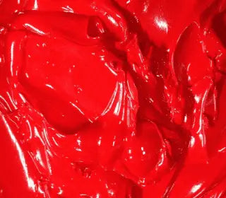 Close-up of solid red plastisol ink, ideal for screen printing on various fabrics.