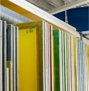 Collection of colorful aluminum screens on display, used for screen printing supplies and processes.