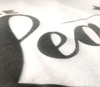 Close-up of screen printed fabric showcasing raised 3-D effect using puffer ink for unique texture.